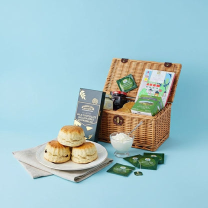Tea hamper with biscuits, cream, and tea bags on a blue background
