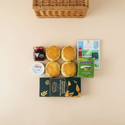 Assorted food items including scones, jam, and a box on a beige background