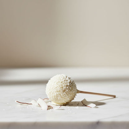 White coconut ball on a light wooden surface with a neutral background