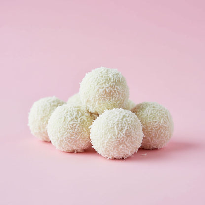 White coconut balls on a pink background
